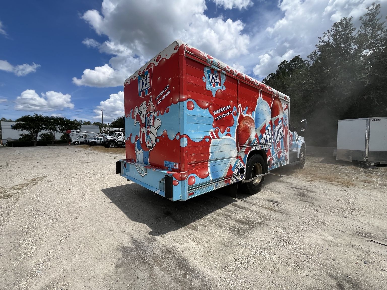 Box truck with a full red and blue printed vinyl wrap before removal