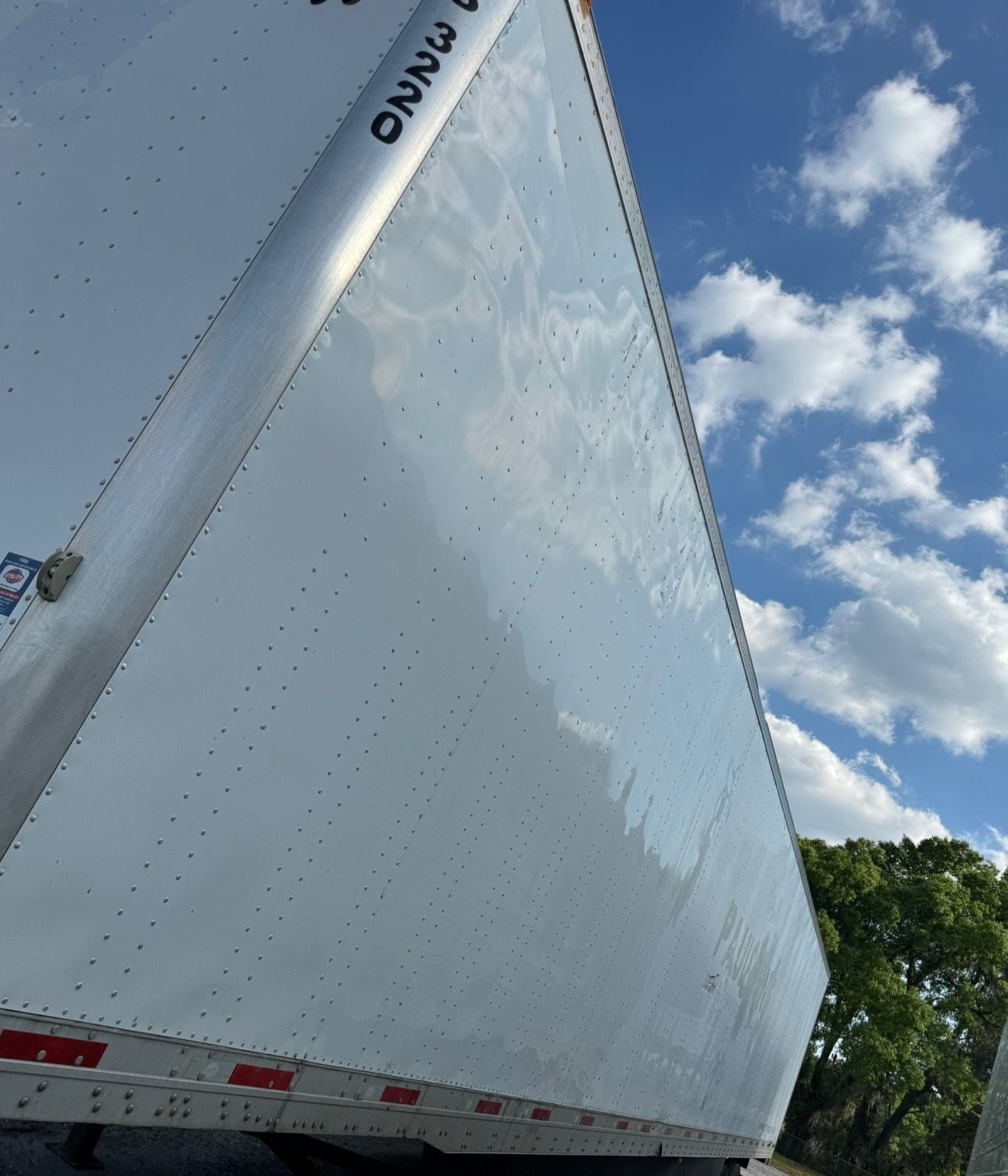 The same dry van panel after graphic and adhesive removal, showing a clean reflective surface