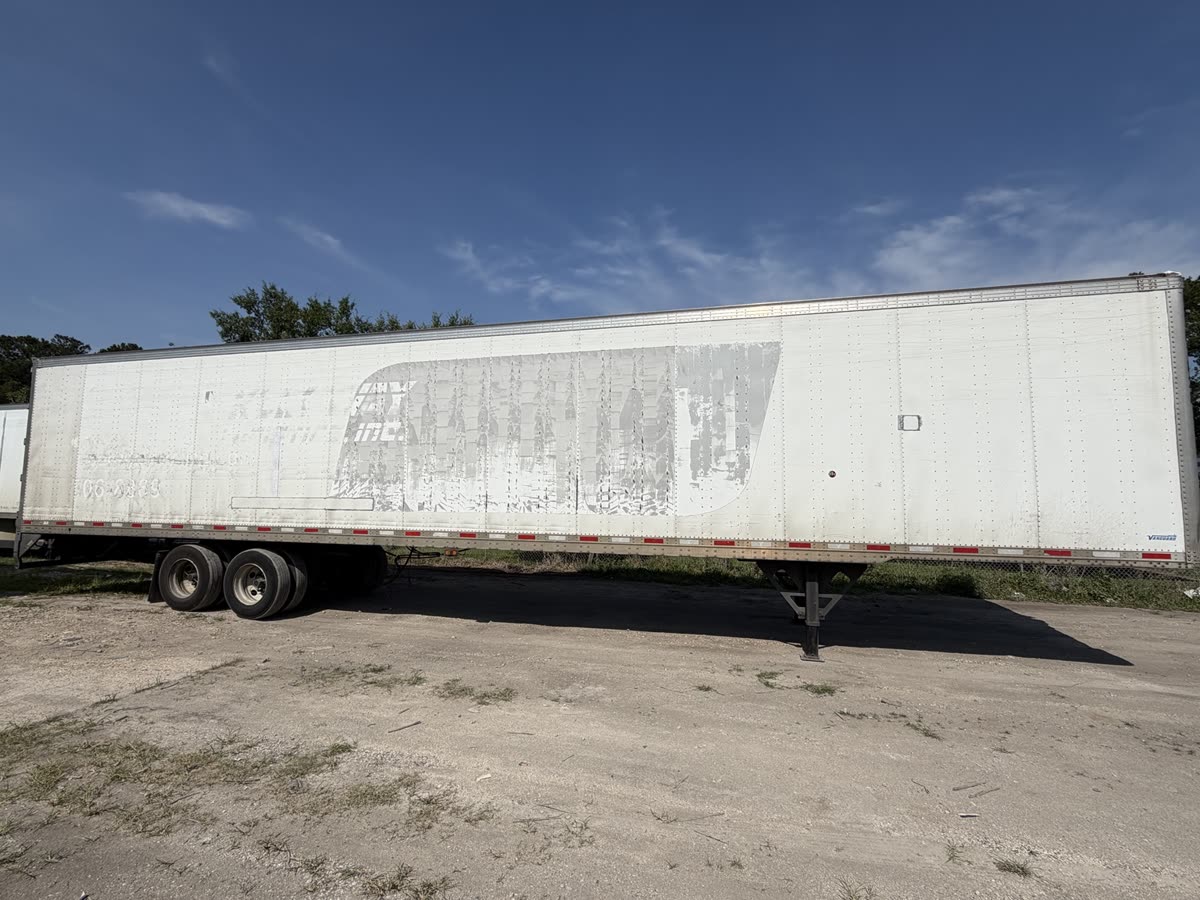 White 53-foot semi-trailer with dirty panels and heavy decal ghosting before washing and aluminum brightening