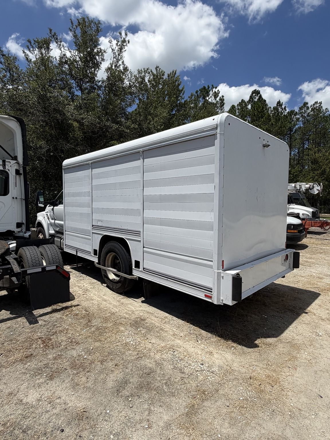 The same box truck with the wrap fully removed, showing a clean white de-identified body